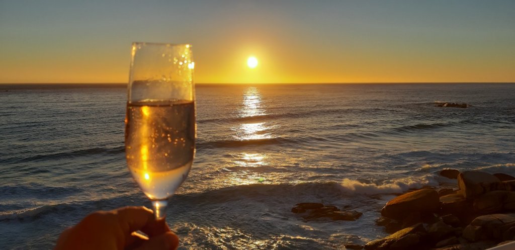 A glass of MCC by the ocean during sunset